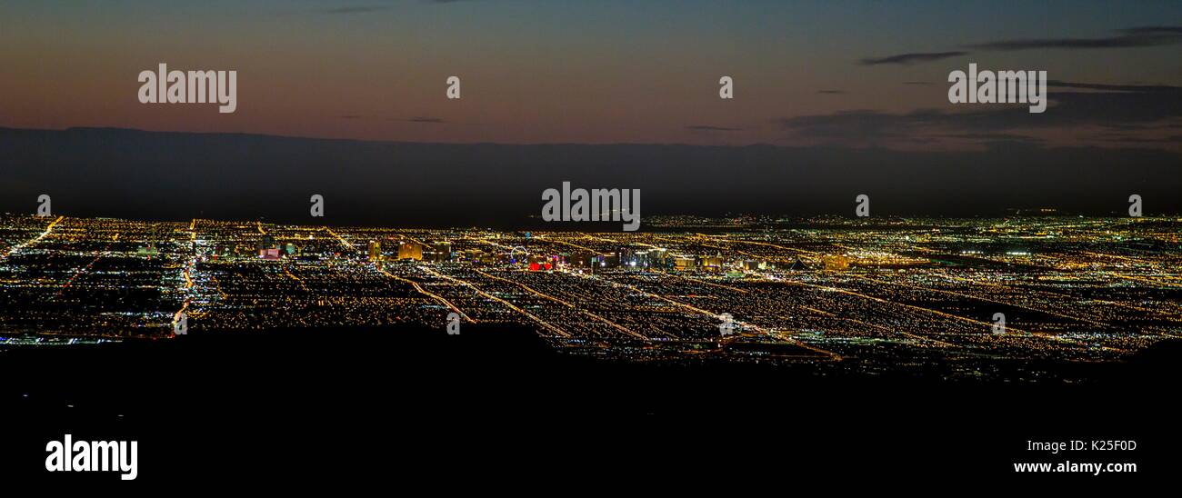 Le luci della città si può vedere di notte da sopra le formazioni rocciose presso il Red Rock Canyon National Conservation Area 27 Settembre 2016 vicino a Las Vegas, Nevada. Foto Stock