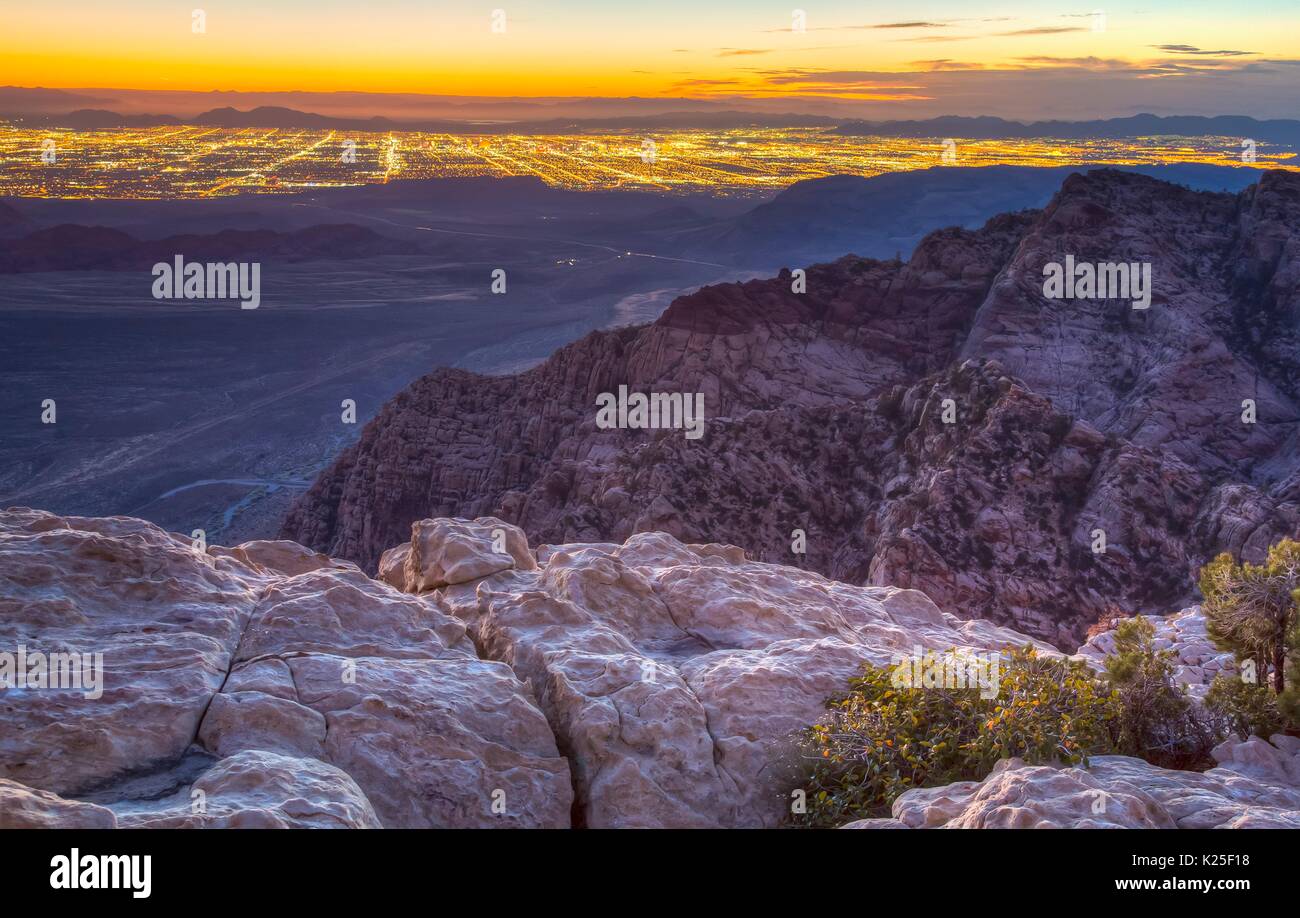 Red formazioni rocciose all'alba al Red Rock Canyon National Conservation Area con il Las Vegas luci a distanza 27 Settembre 2016 vicino a Las Vegas, Nevada. Foto Stock
