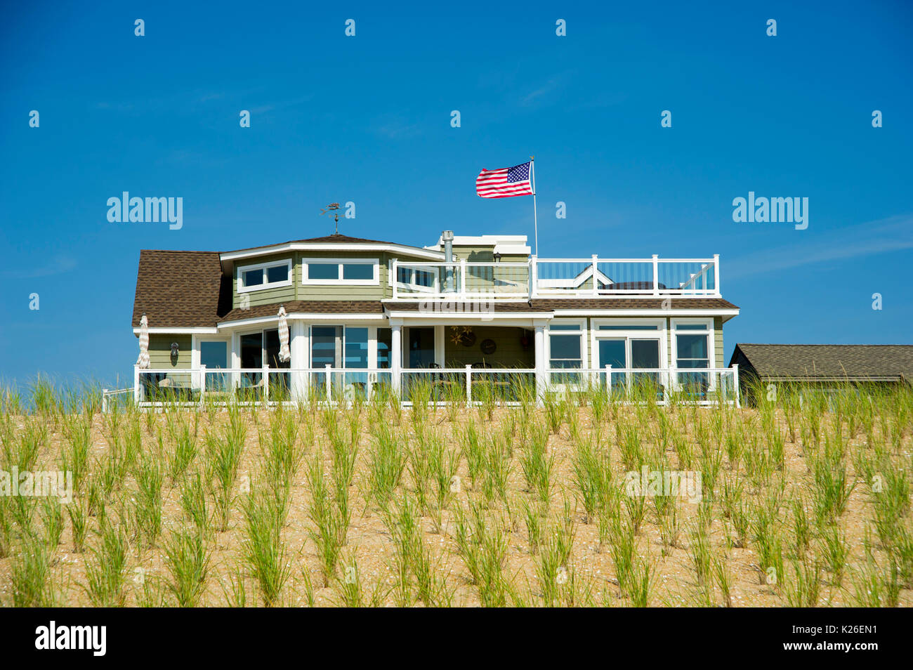 Casa sulla spiaggia sulle dune con bandiera americana Foto Stock