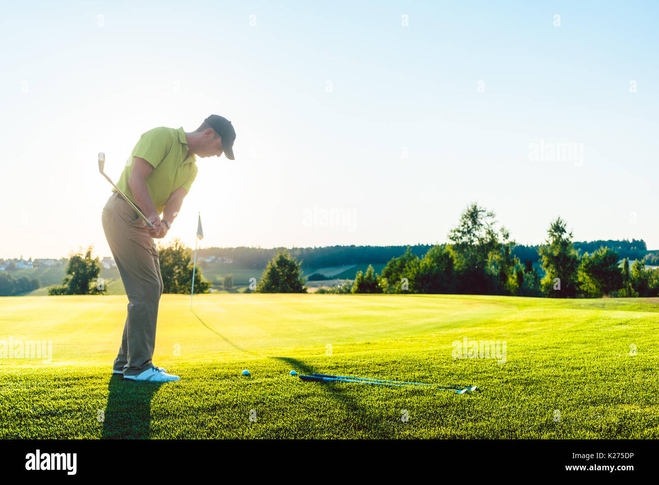 Esperto golfista maschio di colpire la pallina da golf verso la coppa du Foto Stock
