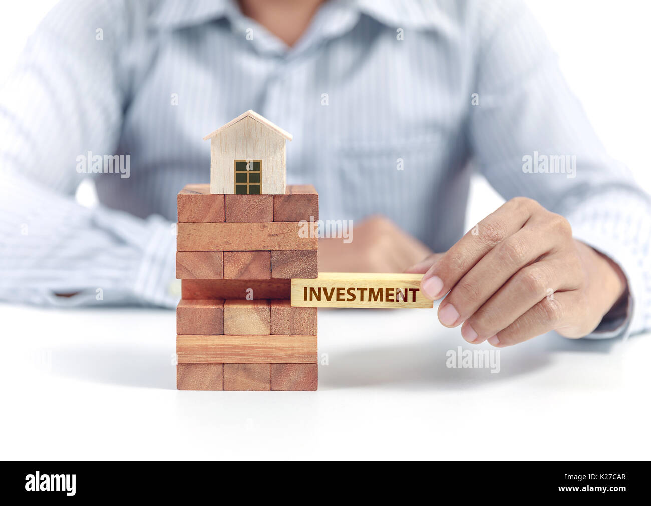 Imprenditore attesa parola investimenti su puzzle in legno con il modello di casa Foto Stock