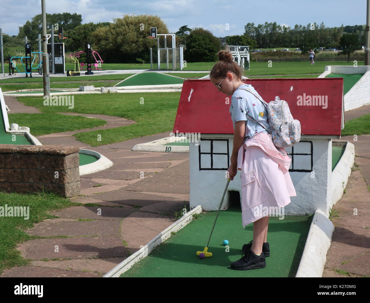 Ragazza giovane giocando adventure golf sul lungomare di Sandown, Isle of Wight, Regno Unito Foto Stock