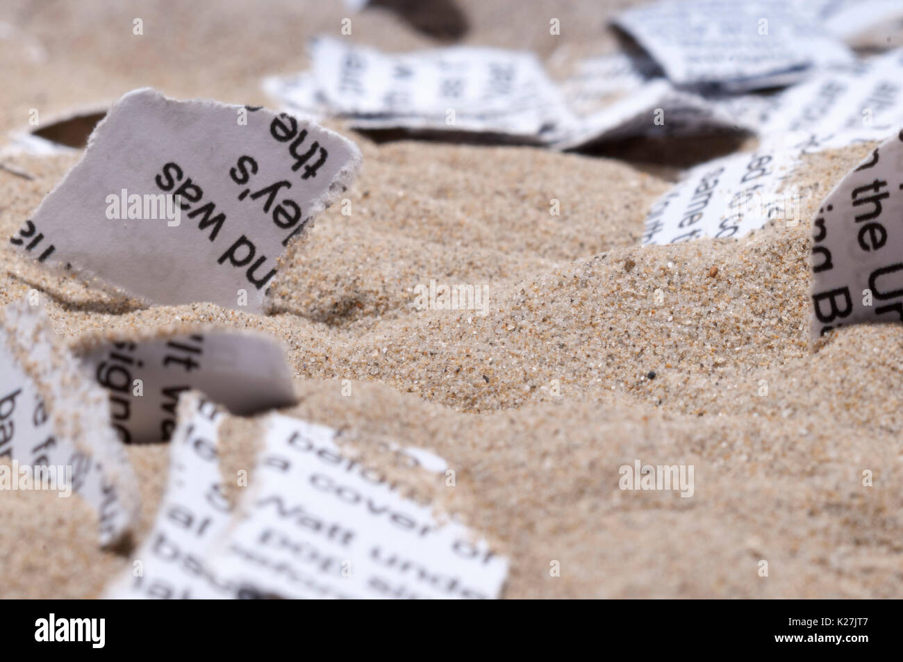 Pezzi di carta nella sabbia Foto Stock