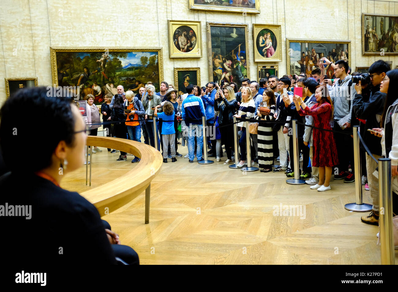 Gli orologi di sicurezza come persone guardano e prendere le foto di la 'Mona Lisa' di Leonardo Da Vinci Settembre 17, 2016 a Parigi, Francia. Foto Stock