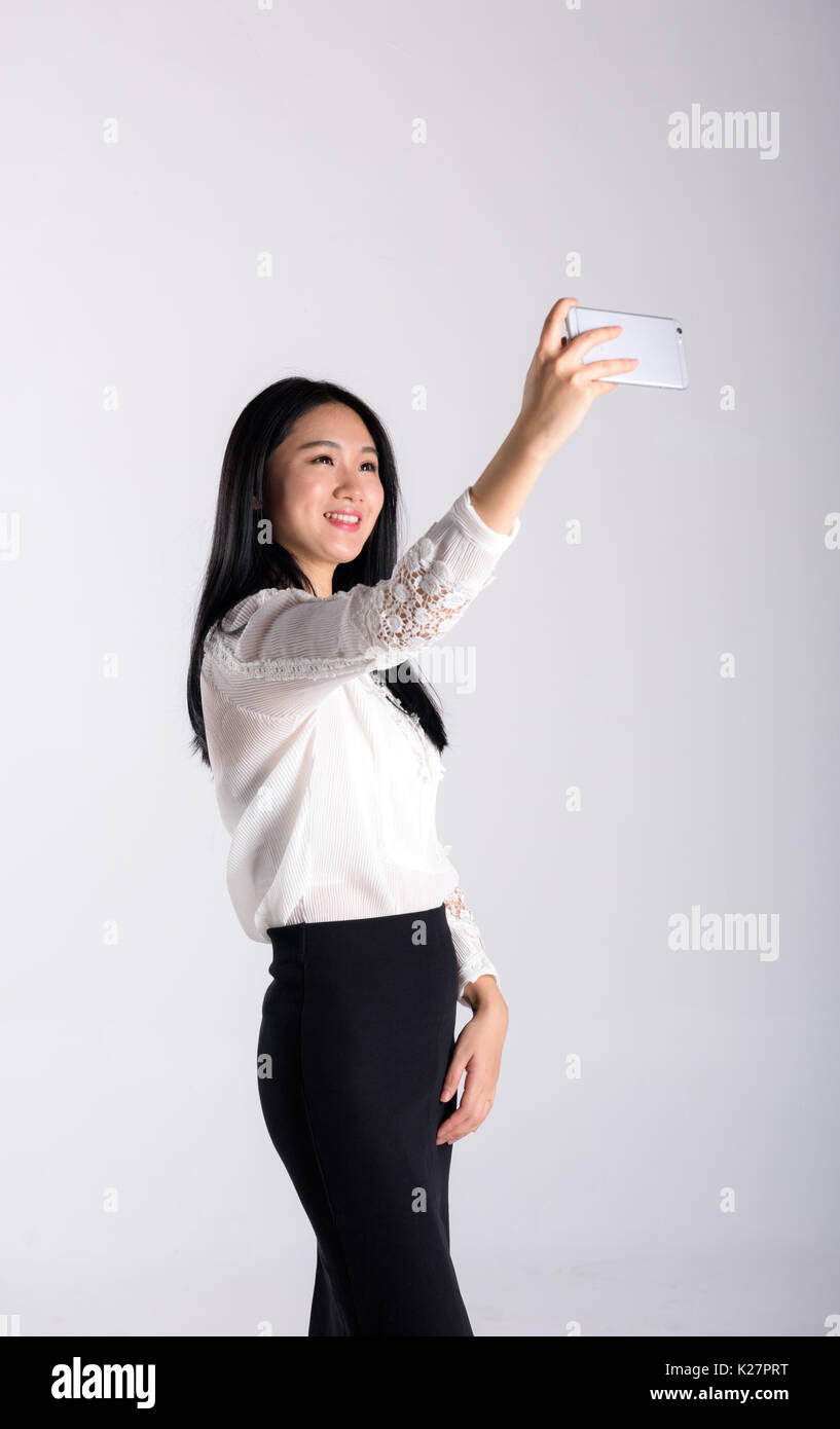 Una giovane donna in possesso di un telefono a prendere auto photo Foto Stock