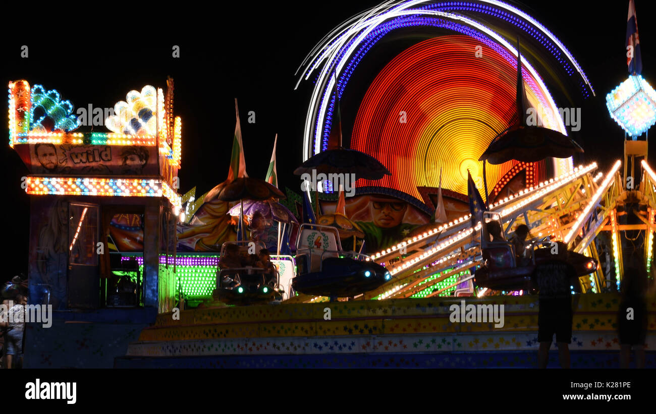 Corse di Midway a fiera del divertimento e colorati di Scena Notturna Foto Stock