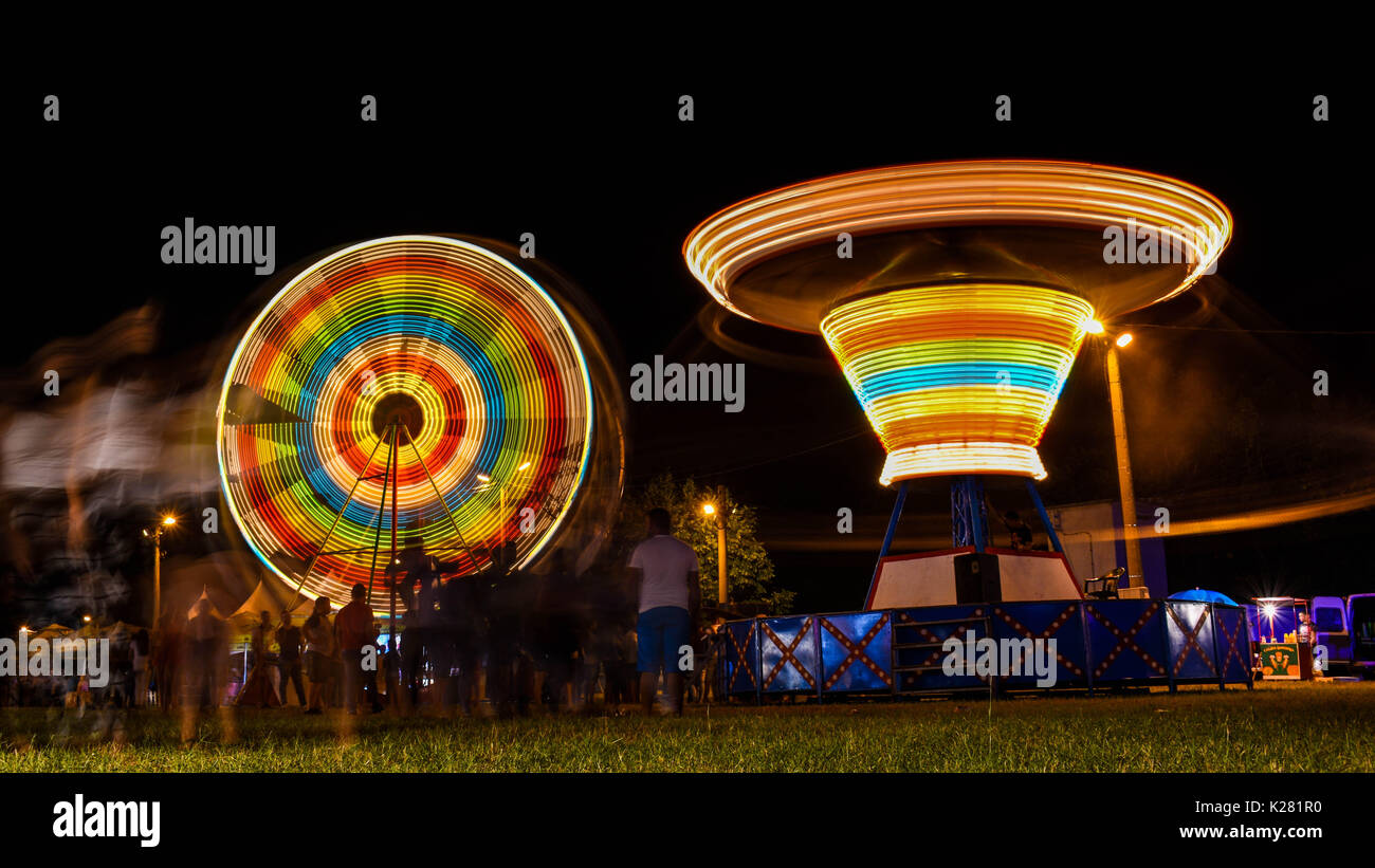Corse di Midway a fiera del divertimento notturno Foto Stock