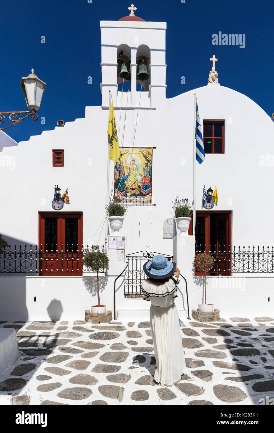 La donna in piedi di fronte a un ortodosso chiesa greca, Mykonos, Grecia. Foto Stock