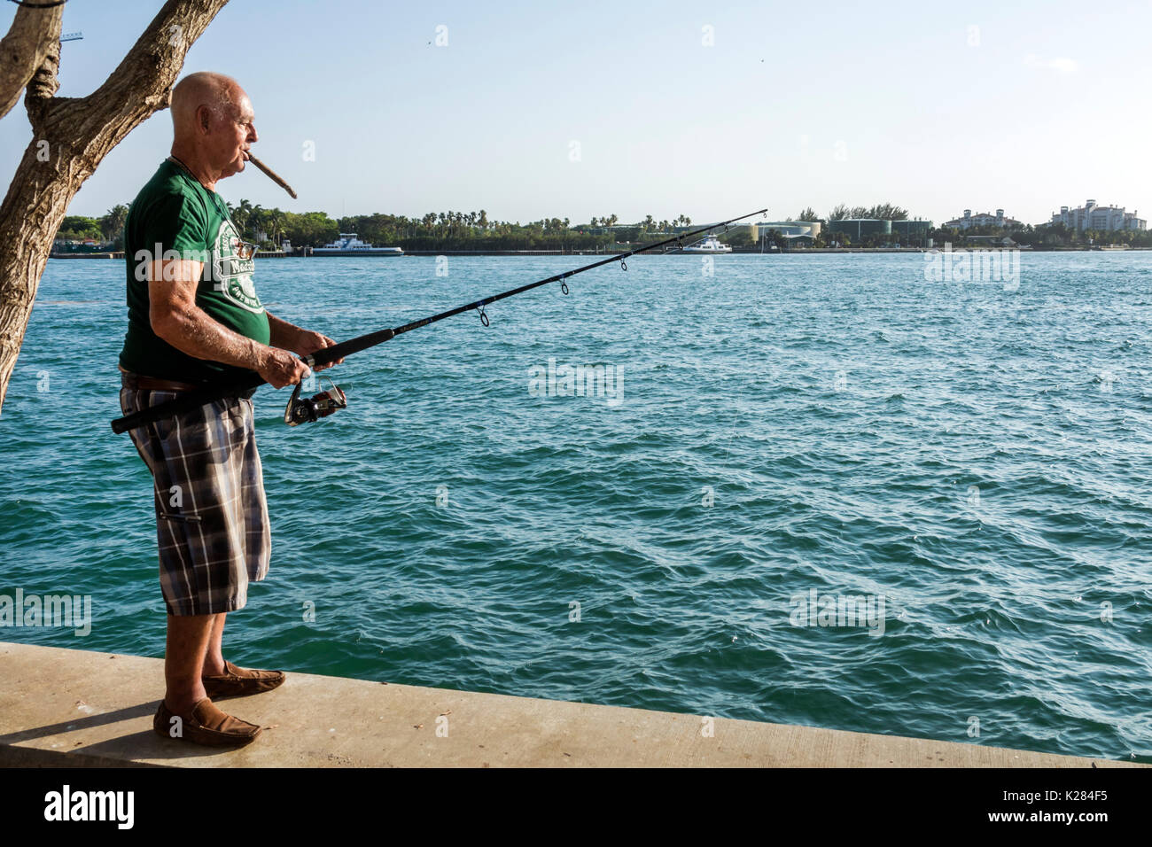 Miami Beach Florida, Bay Walk, marina, lungomare, uomo uomini maschi, pesca, fumatori sigaro, cittadini anziani ispanici anziani, taglio governativo, FL170430243 Foto Stock