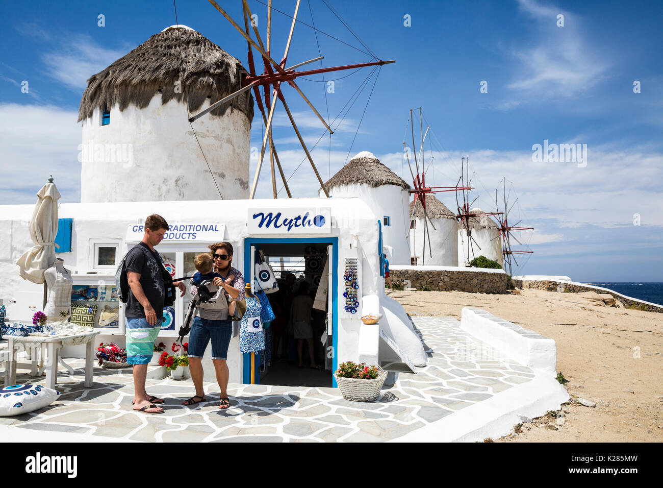 I turisti in un negozio di souvenir accanto ai mulini a vento di Kato, Mykonos, Grecia. Foto Stock