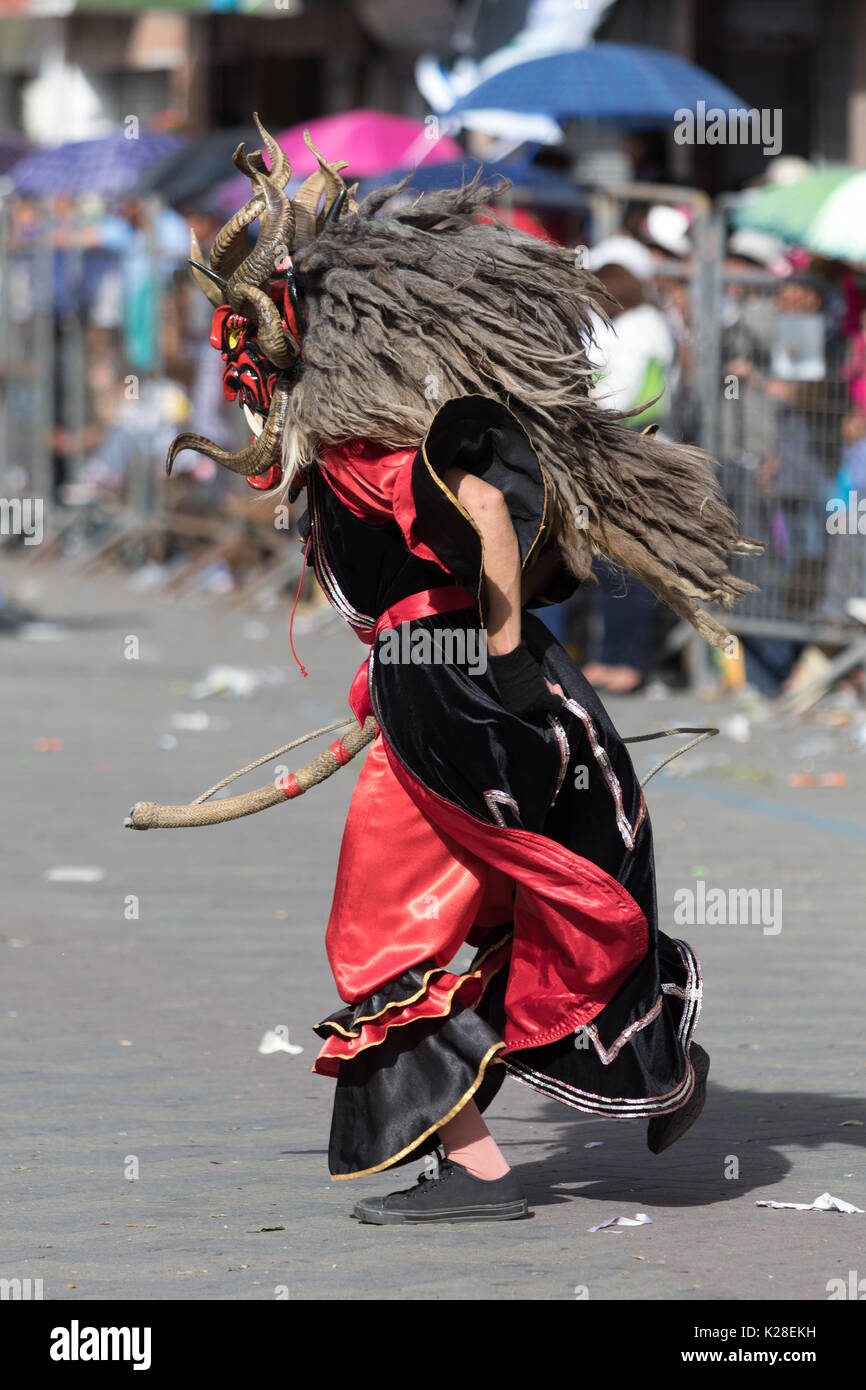 Giugno 17, 2017 Pujili, Ecuador: Ingrandimento di un ballerino maschio con i tradizionali colorati maschera facciale presso il Corpus Christi parata annuale Foto Stock