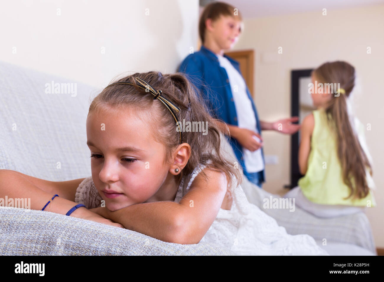 Invidia bambino seduto da parte di un ragazzo e la sorella a casa Foto Stock