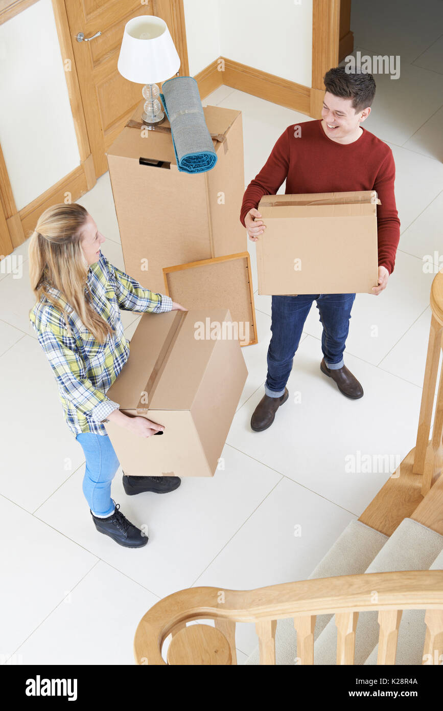Coppia giovane recanti caselle a muoversi in giorno Foto Stock