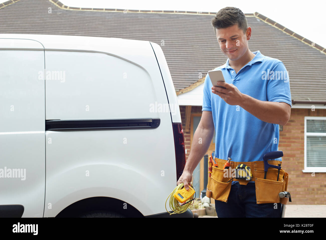 Elettrauto controllo messaggio sul telefono cellulare Foto Stock