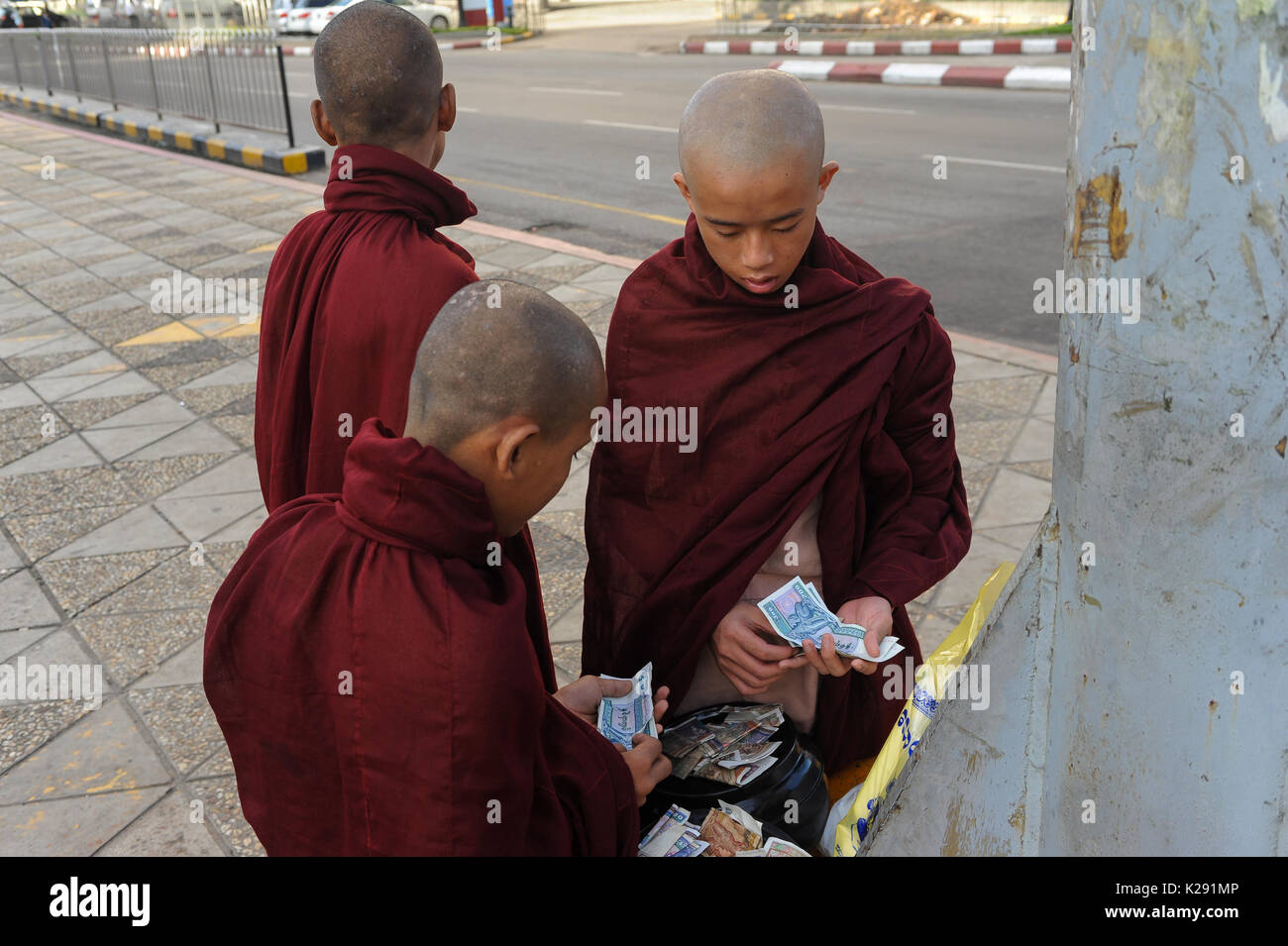 19.10.2013, Yangon, Repubblica dell' Unione di Myanmar, Asia - Novice i monaci sono visto in corrispondenza di un incrocio stradale contando le erogazioni liberali in denaro. Foto Stock