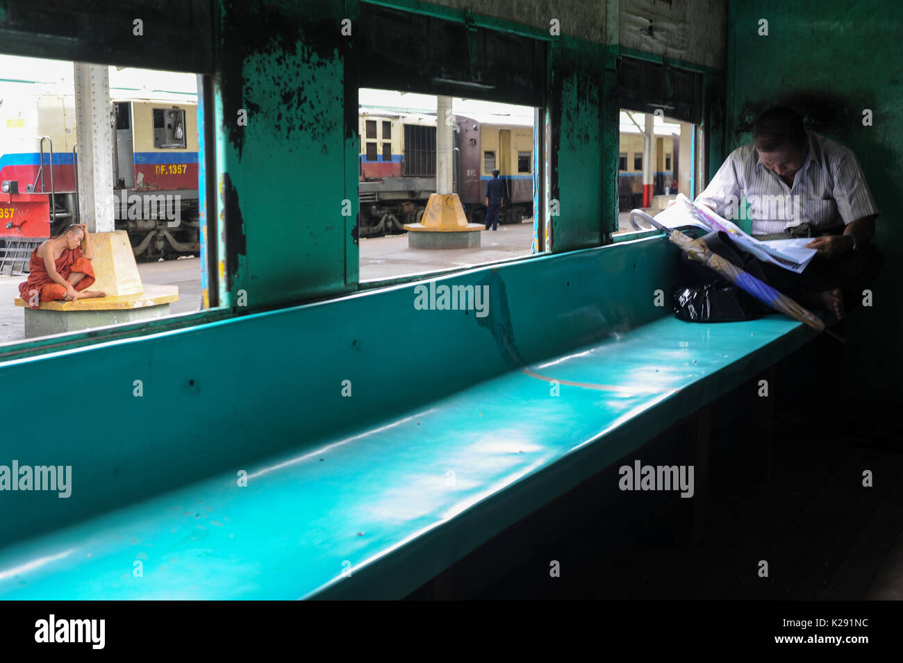 04.08.2013, Yangon, Repubblica dell' Unione di Myanmar, Asia - un monaco buddista è visto in appoggio alla piattaforma di Yangon la principale stazione ferroviaria. Foto Stock