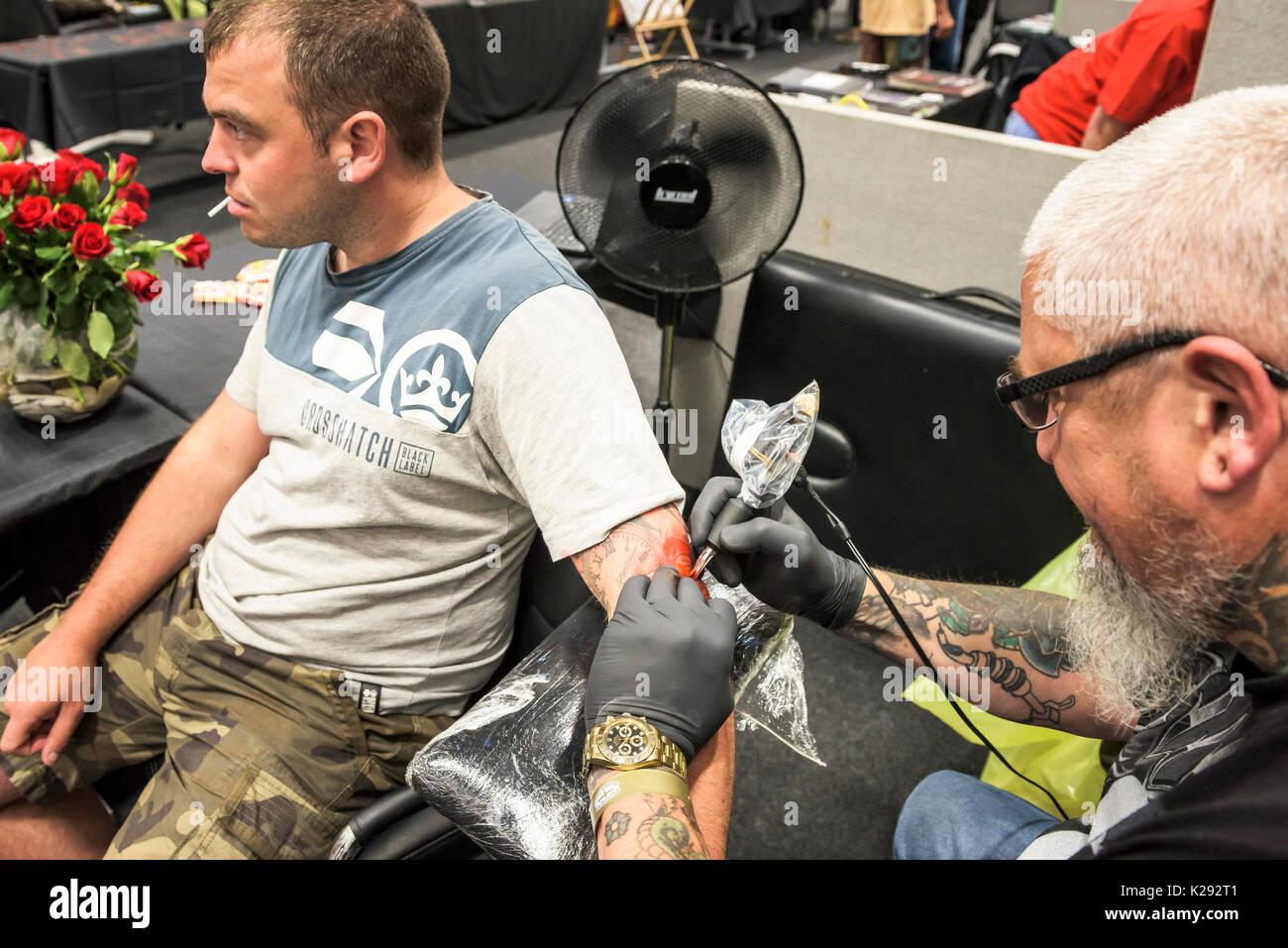 Tatuaggio - Giovanni da Hells Gates Tattoo Studio tatuaggio al braccio di un cliente al Cornwall Tattoo Convention. Foto Stock