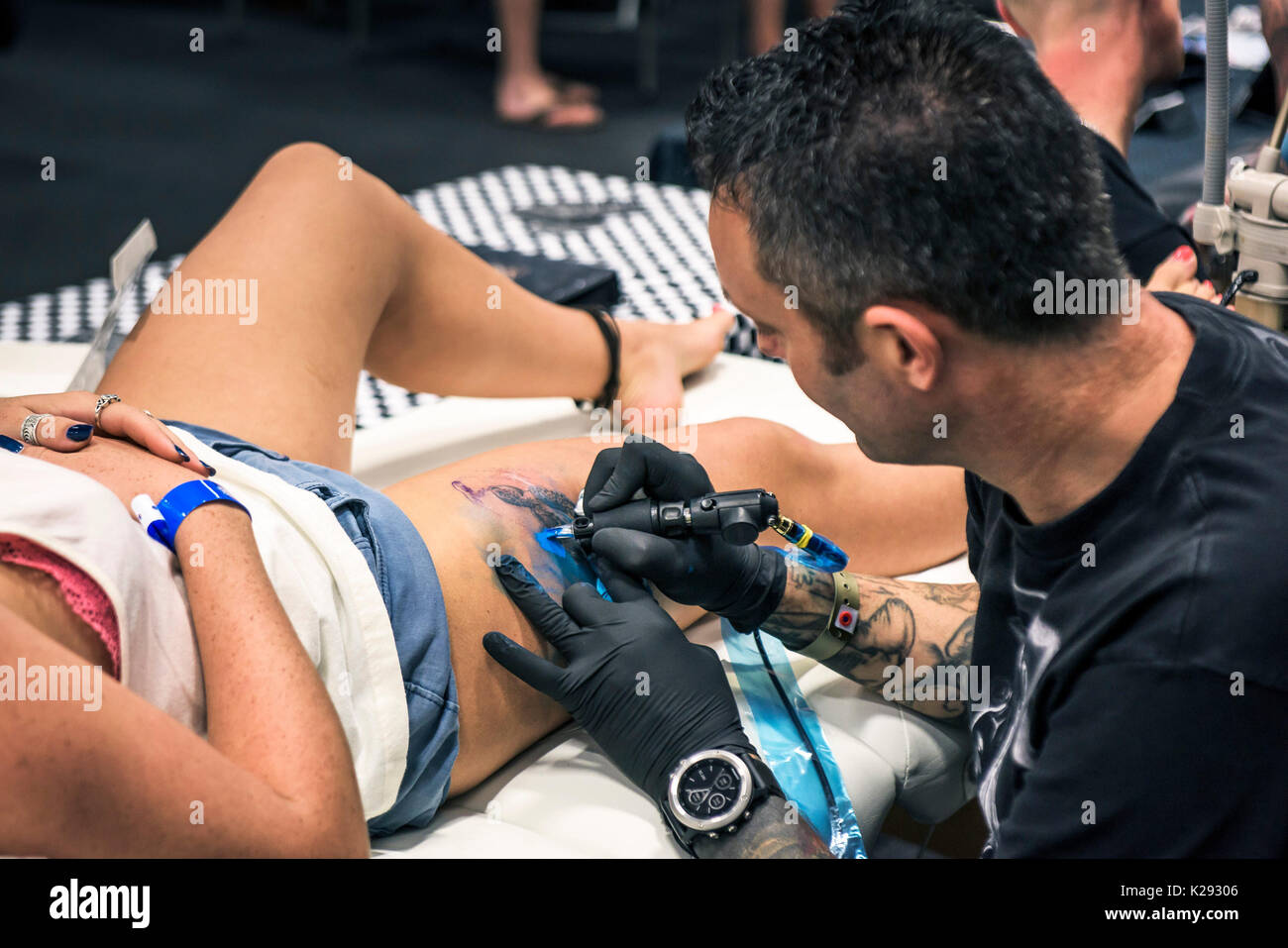 Tattooist - Marco razza tatuaggio un disegno sulla coscia di una femmina di cliente al Cornwall Tattoo Convention. Foto Stock
