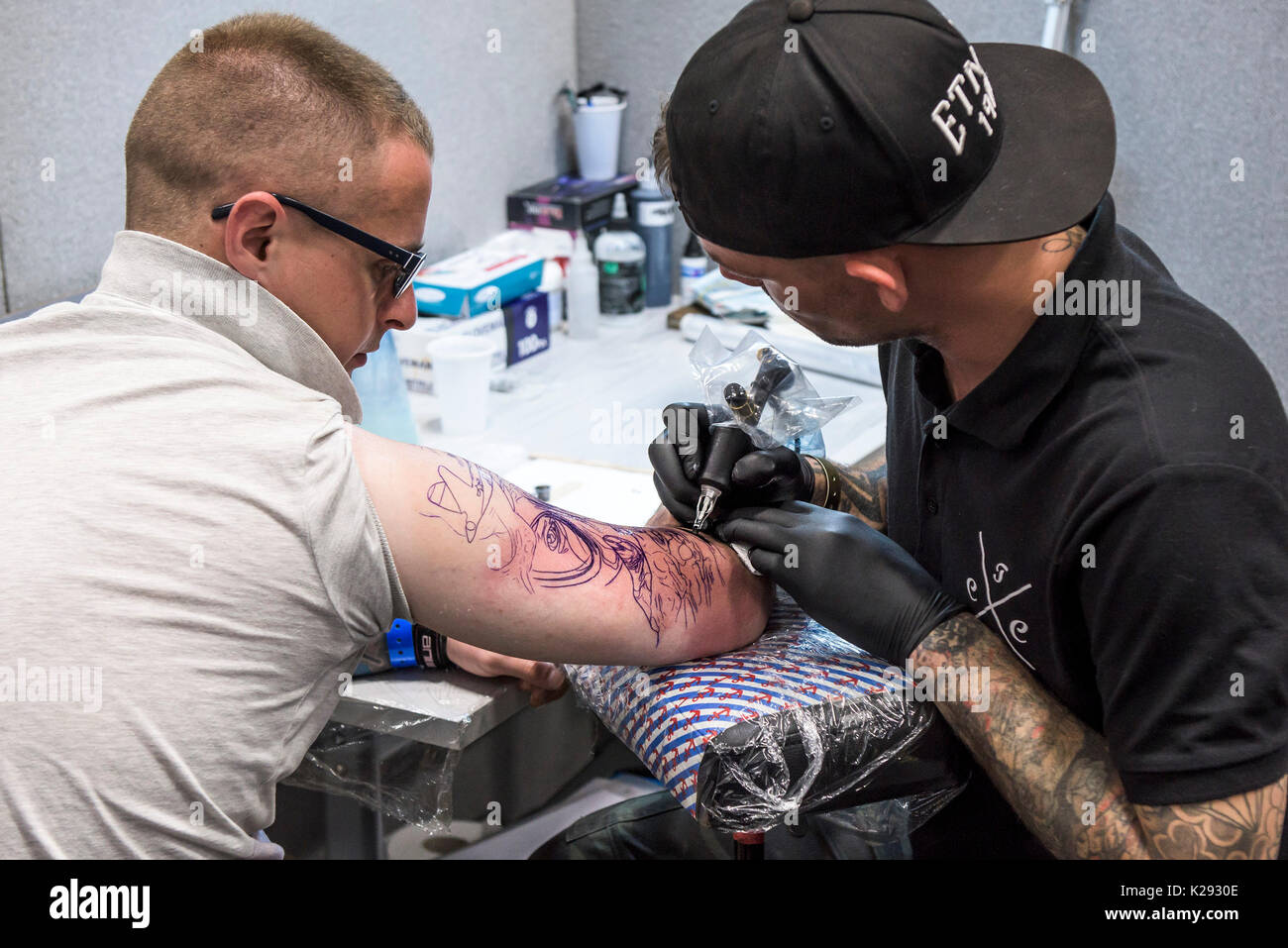 Cornovaglia Tattoo Convention - un uomo avente il suo braccio superiore tatuati in Cornovaglia Tattoo Convention. Foto Stock
