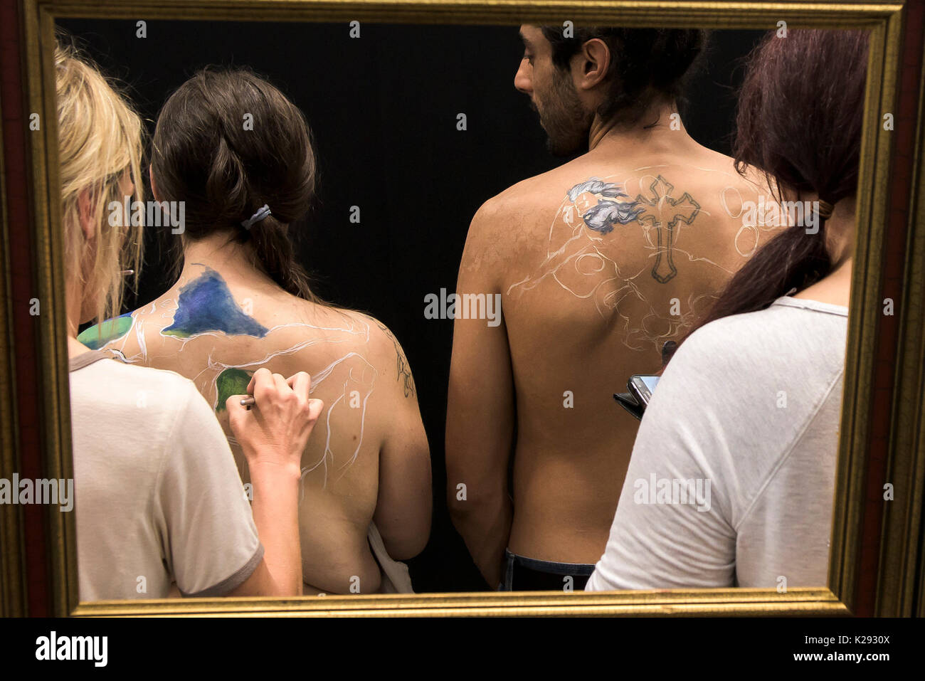 Body Painting - un uomo e una donna si vede attraverso un telaio avente le spalle dipinta dal corpo di nicotina pittura presso la Cornovaglia Tattoo Convention. Foto Stock