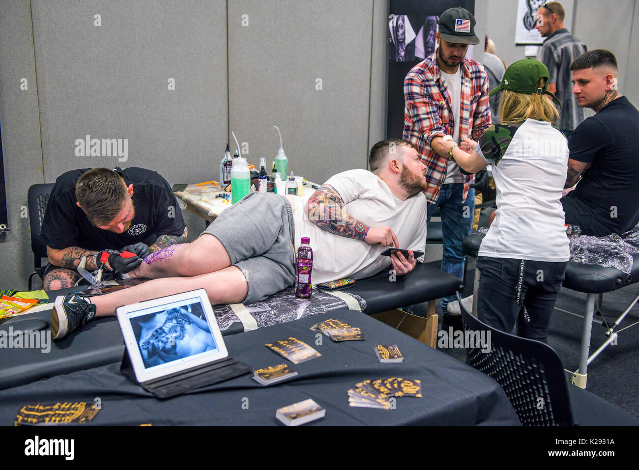 Cornovaglia Tattoo Convention - un uomo avente la sua gamba tatuati in Cornovaglia Tattoo Convention. Foto Stock