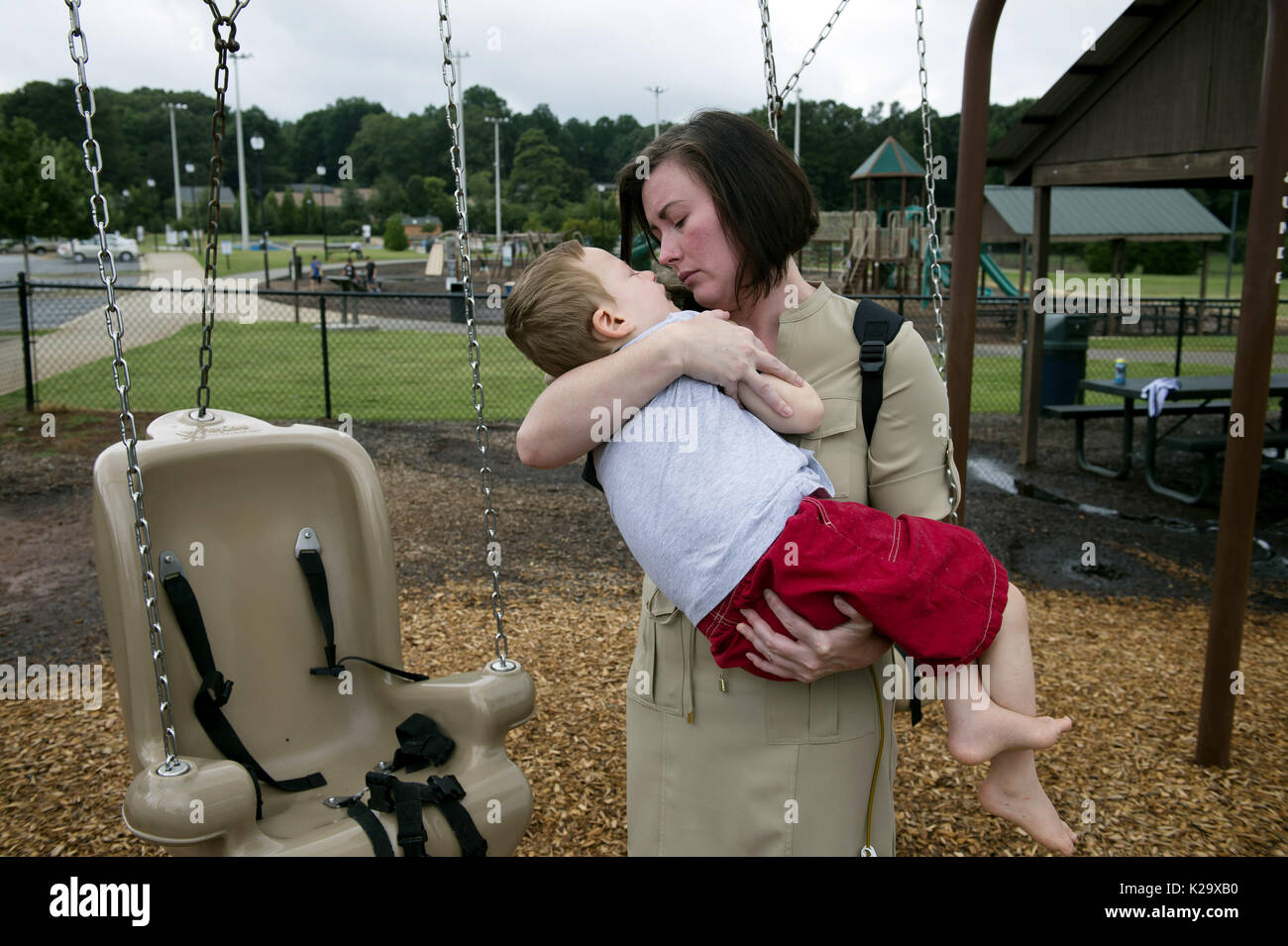 Marietta, Georgia, Stati Uniti d'America. 8 Ago, 2017. SARAH ALLEN invita il figlio a godere di un apposito atto oscillare in un parco nelle vicinanze. Indossa questo tubo di alimentazione pompa nel suo zaino, e Aidan è collegato alla pompa per 20 ore ogni giorno. Allen è sia madre single e full-time - anche se il personale non addestrato -infermiera a suo figlio AIDAN, nato con paralisi cerebrale e complesse questioni mediche. Credito: Robin Rayne Nelson/zReportage.com/ZUMA filo/Alamy Live News Foto Stock