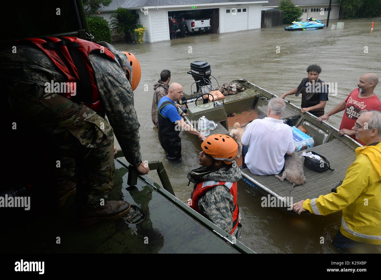 Texas, Stati Uniti d'America. 28 Agosto, 2017. Texas nazionale soldati di guardia e di fuoco volontari e il personale di soccorso evacuare i residenti e i loro animali domestici intrappolato dalle inondazioni a seguito dell'Uragano Harvey Agosto 28, 2017 in cipresso, Texas. Credito: Planetpix/Alamy Live News Foto Stock