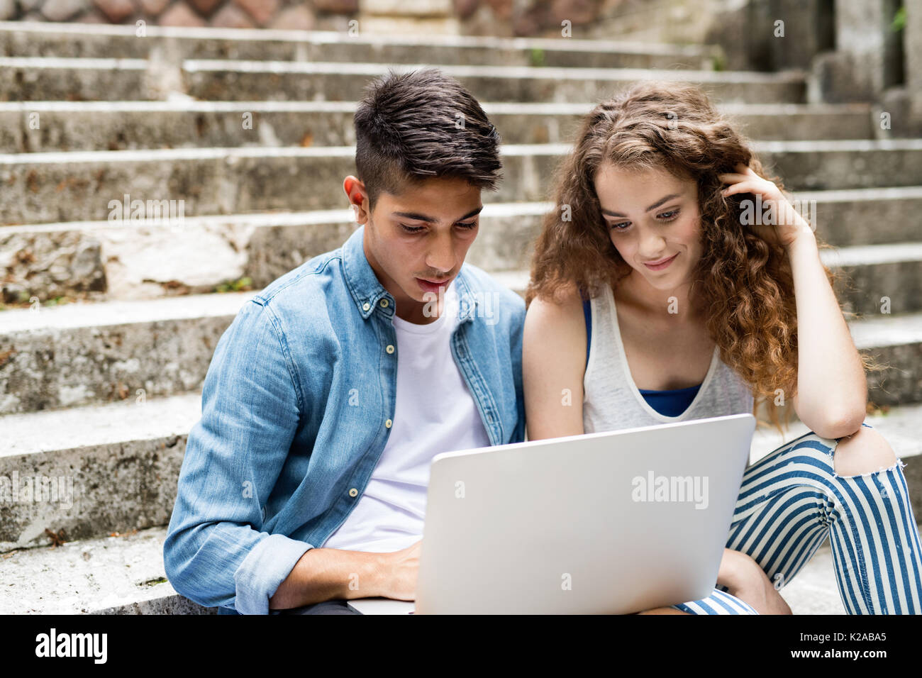 Gli studenti adolescenti con laptop seduto sui gradini di pietra. Foto Stock