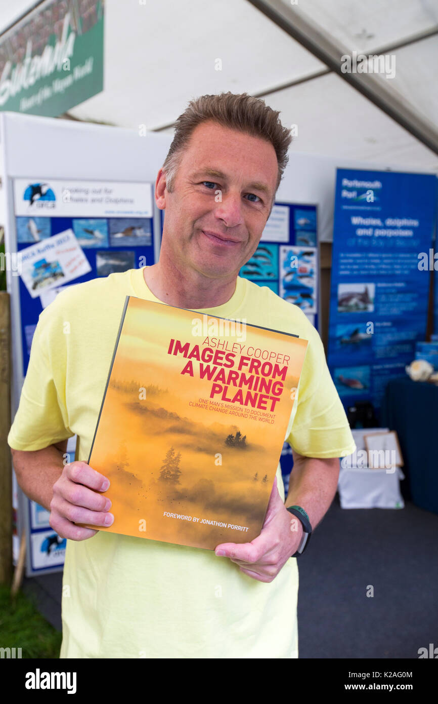 Chris Packham con una copia di Ashley Coopers premiato libro, immagini da un pianeta di riscaldamento. Foto Stock