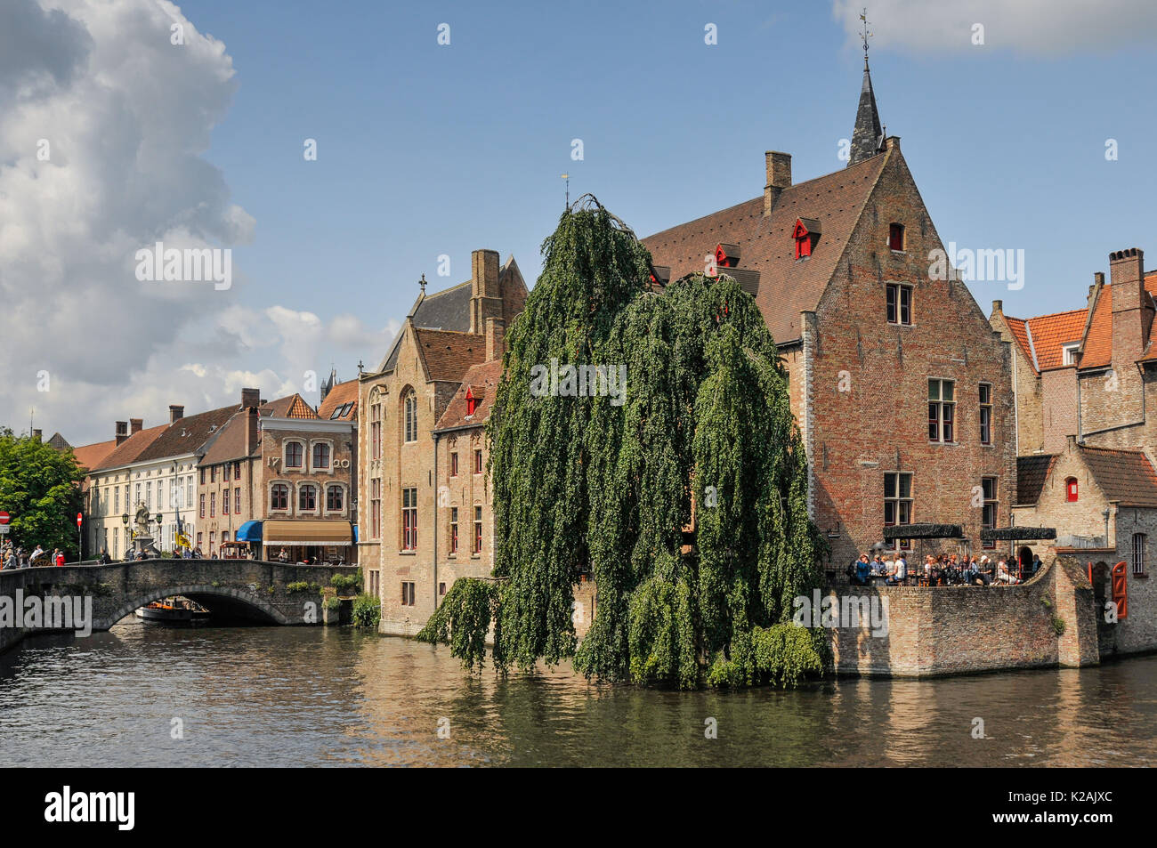 La vista dalla rosenhoedkaai dal subacqueo nella città medievale di Brugge / Bruges in Belgio su una soleggiata giornata estiva con i turisti in un bar terrazza Foto Stock