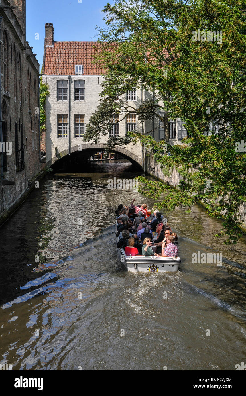 I turisti in una gita in barca dei canali nella città medievale di Brugge / bruges in Fiandra occidentale in Belgio Foto Stock
