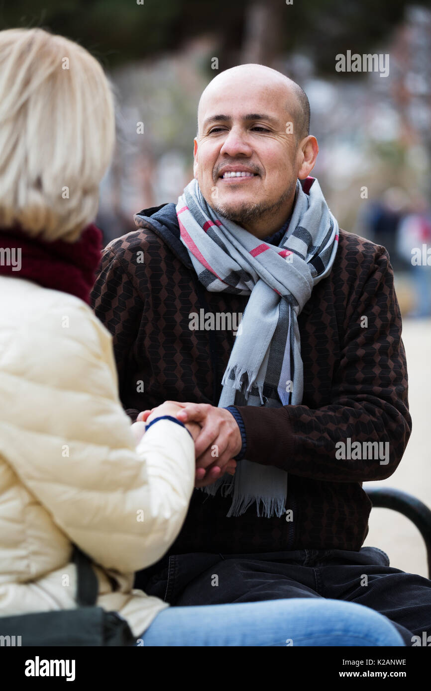 Coppia di pensionati positivo in chat e ridere in strada Foto Stock