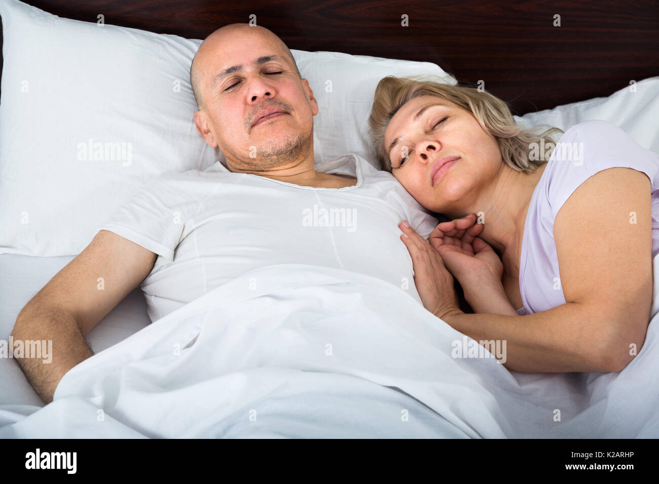 Amorevole famiglia senior di accoppiare a tenuta di dormire nel letto di notte. Focus sull'uomo Foto Stock