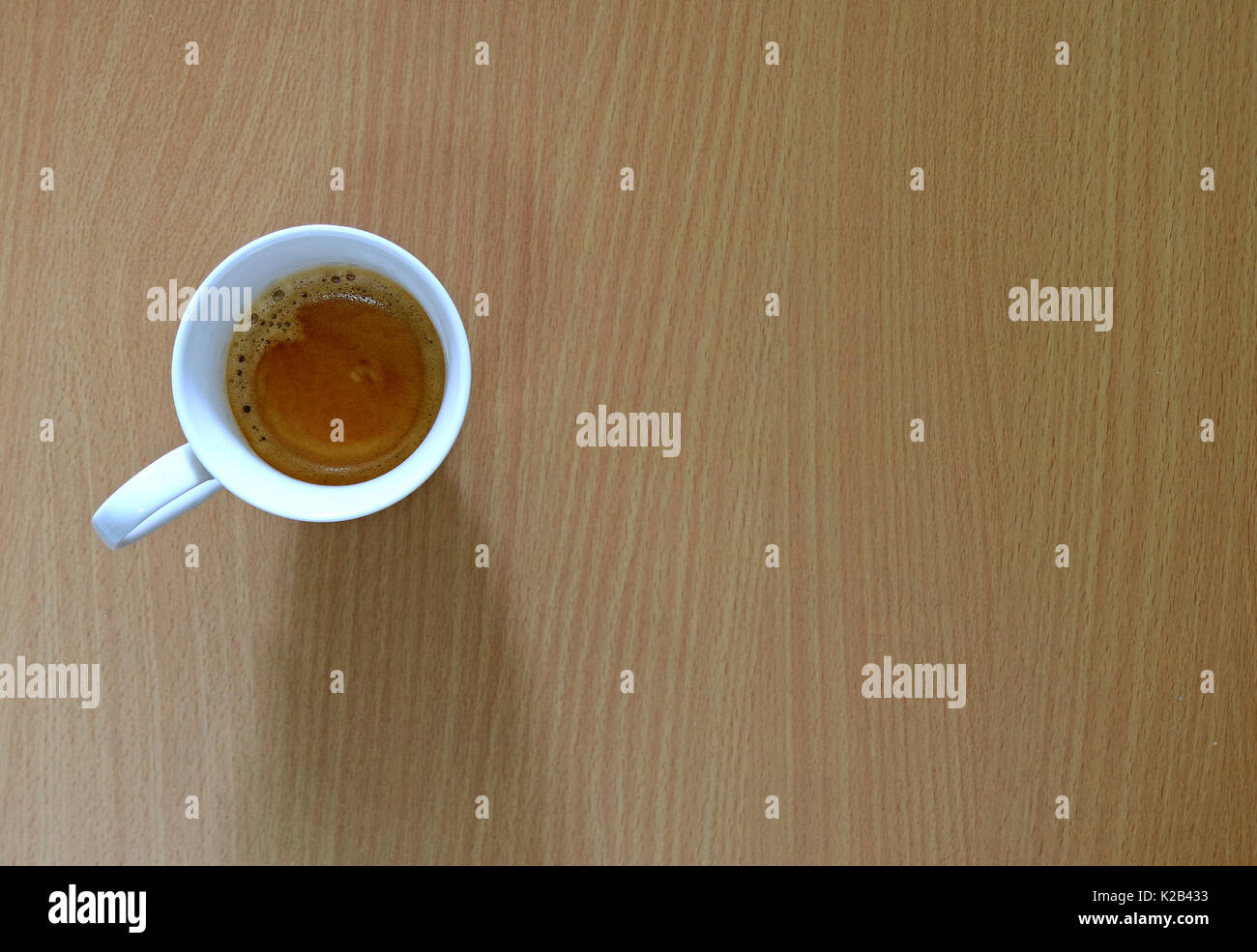 Una tazza di caffè sulla luce marrone tavolo in legno, vista dall'alto Foto Stock