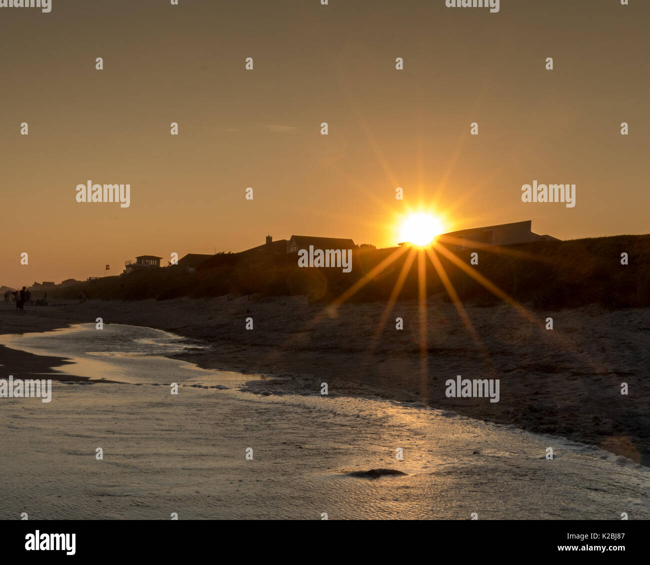 Tramonto sul isola di smeraldo Oceano - Fronte Spiaggia Case sull orizzonte di onde che si infrangono Marea presi durante la vacanza in spiaggia @ OBX Foto Stock