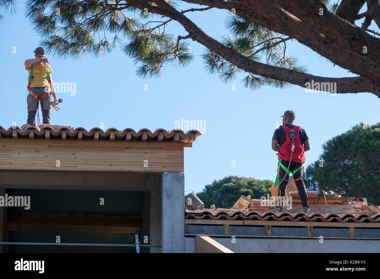 Conciatetti al lavoro installazione di piastrelle in una nuova casa in Provenza, Francia Foto Stock