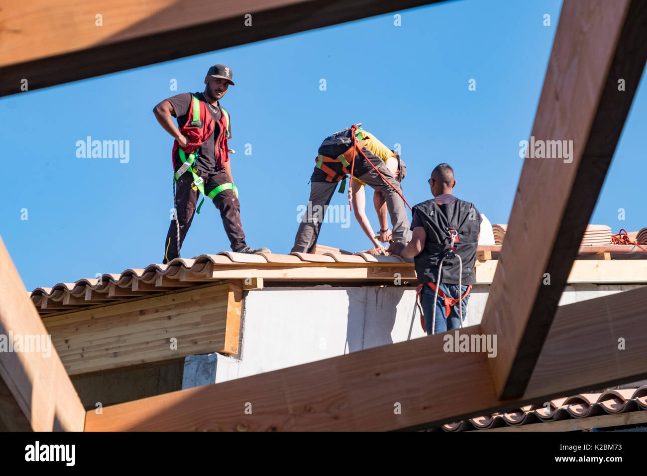 Conciatetti al lavoro installazione di piastrelle in una nuova casa in Provenza, Francia Foto Stock