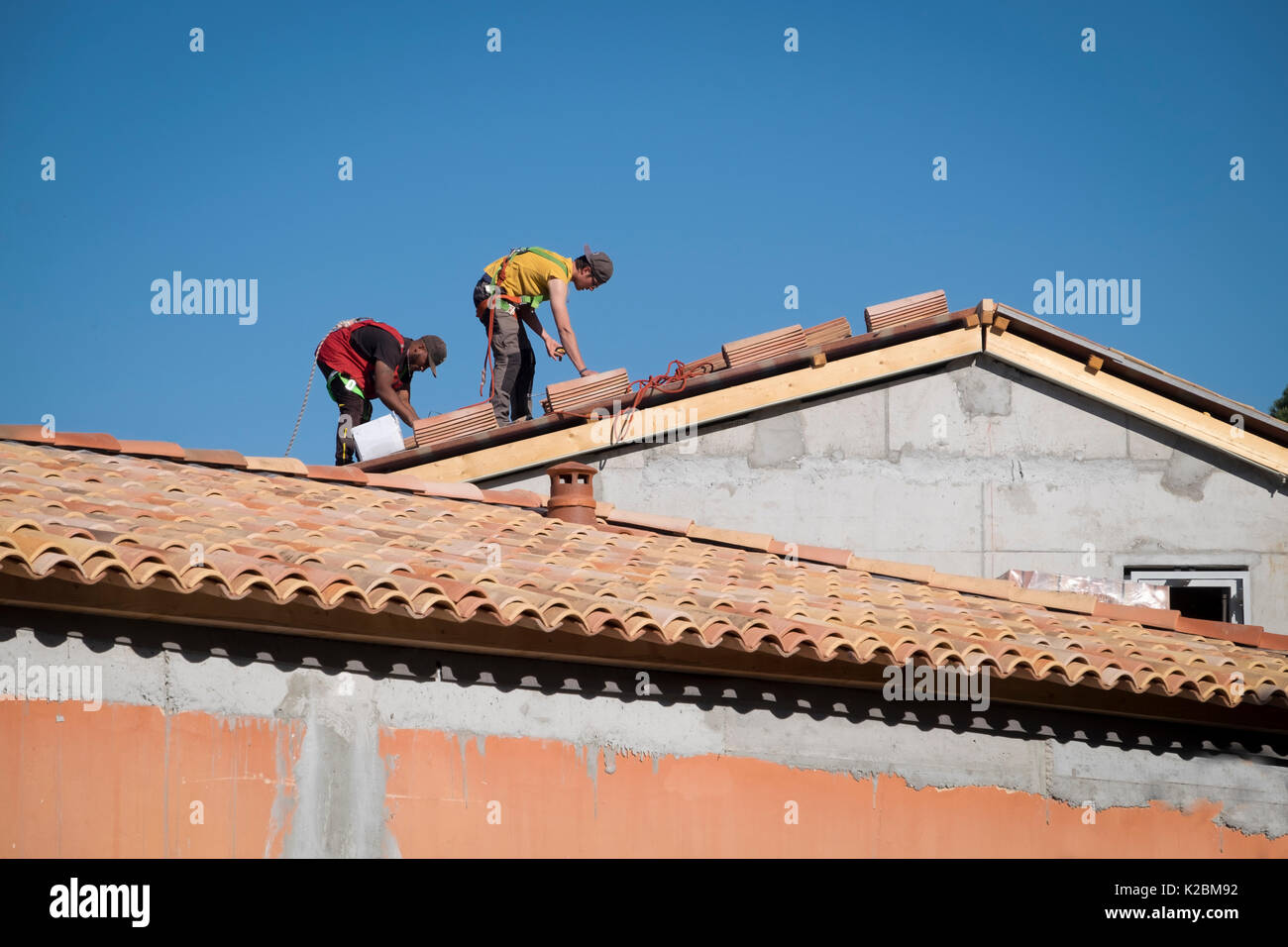 Conciatetti al lavoro installazione di piastrelle in una nuova casa in Provenza, Francia Foto Stock