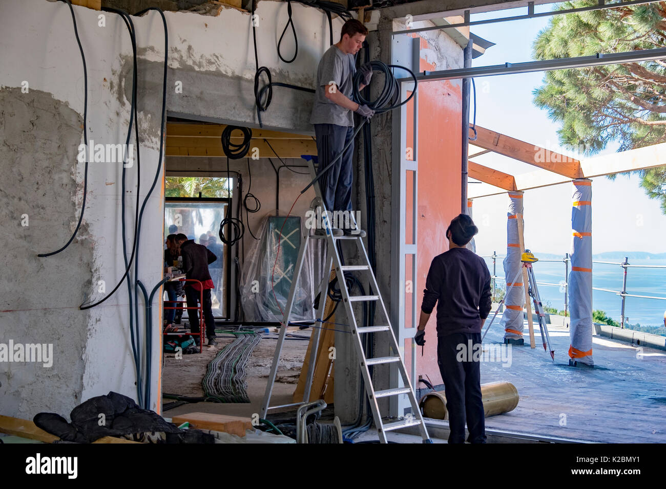 Elettricisti lavoro sul cablaggio di una nuova casa in costruzione sulla Costa Azzurra nel sud della Francia Foto Stock