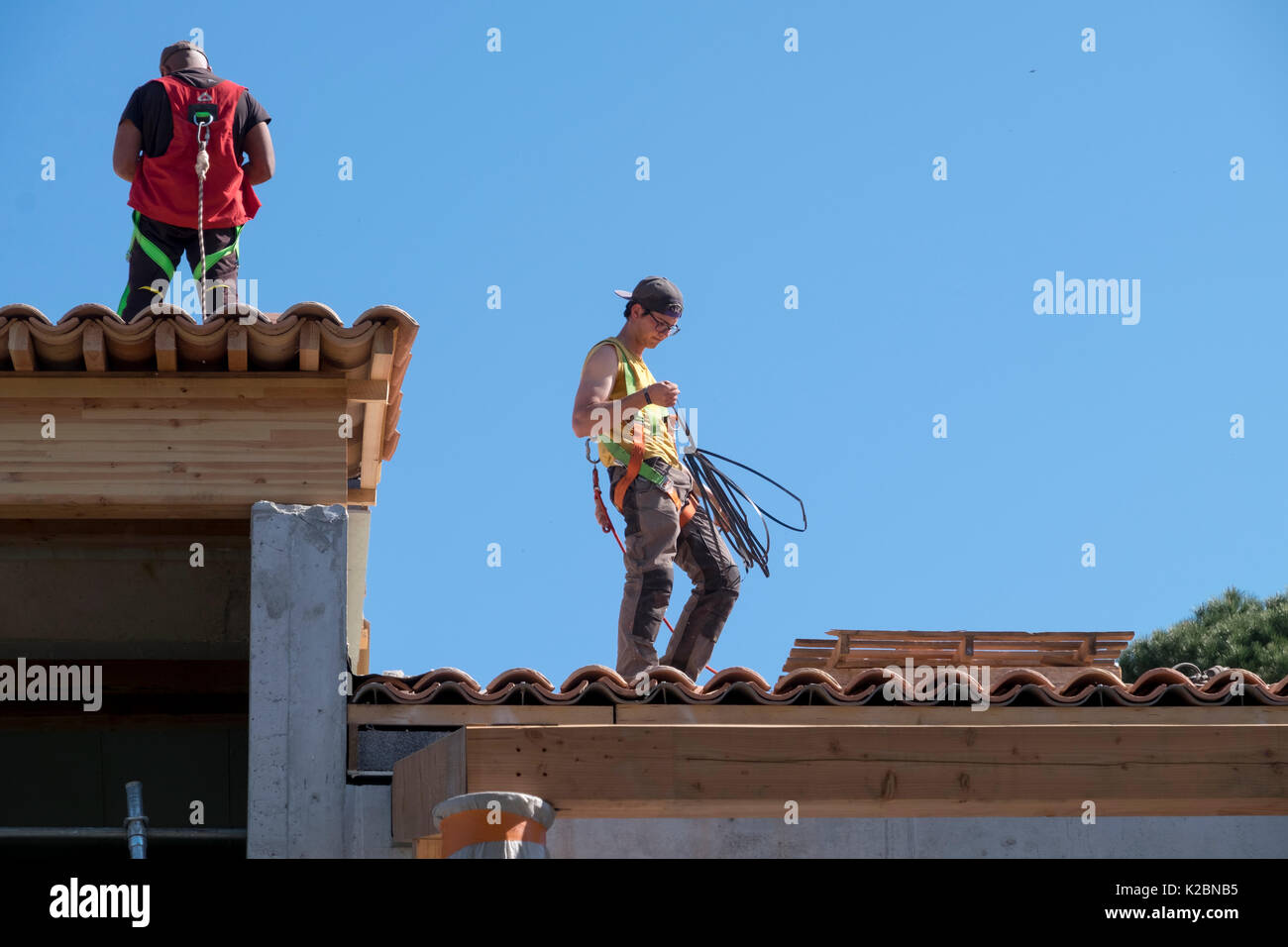 Conciatetti al lavoro installazione di piastrelle in una nuova casa in Provenza, Francia Foto Stock