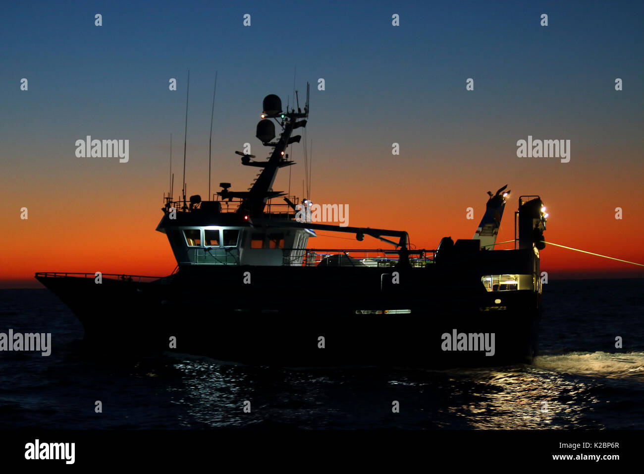 Barca da pesca Harvester all'alba in West Ebridi, Scotland, Regno Unito. Febbraio 2016. Foto Stock