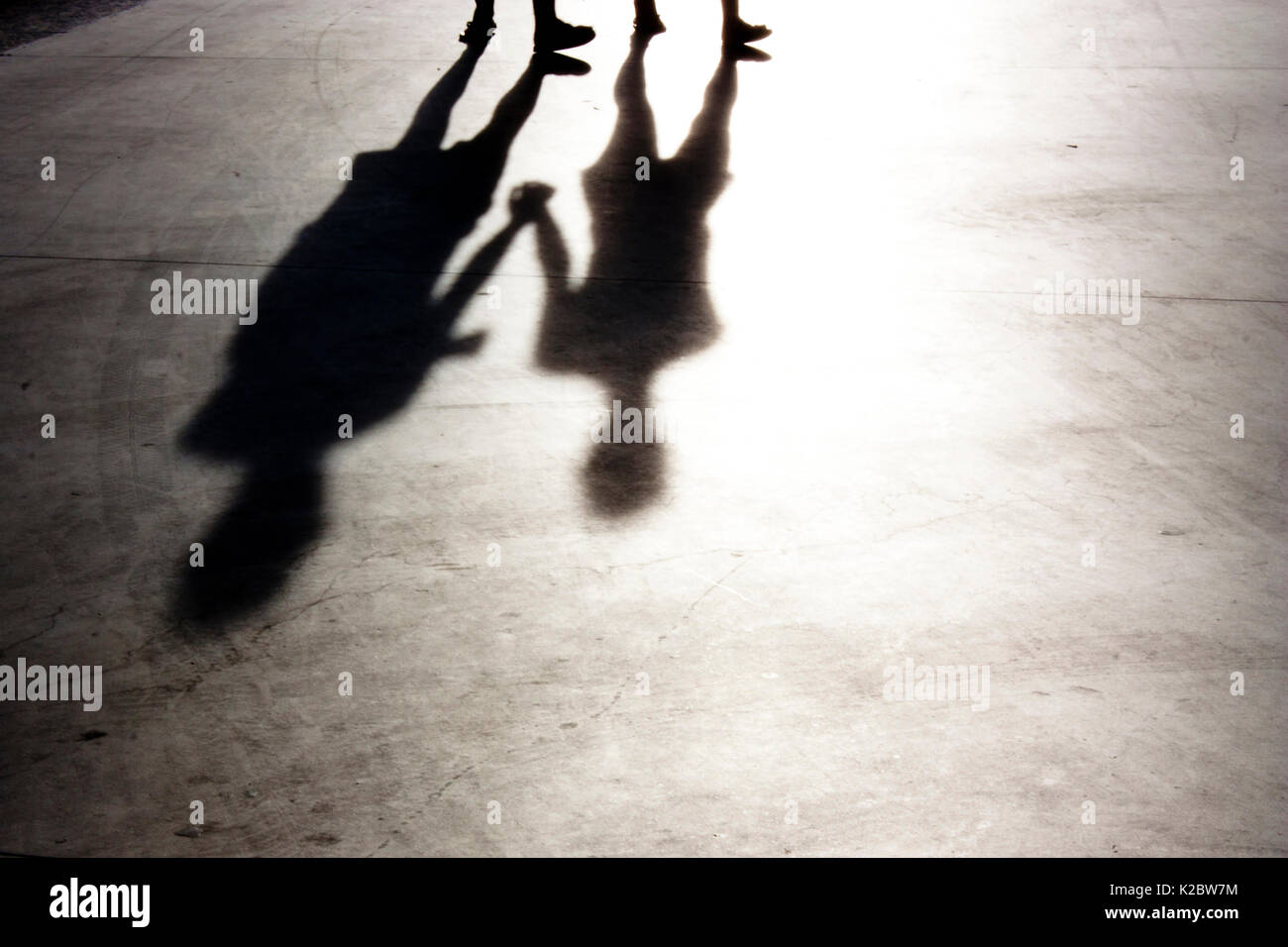 Sfocata due persone tenendo le mani a piedi silhouette e ombre in bianco e nero Foto Stock