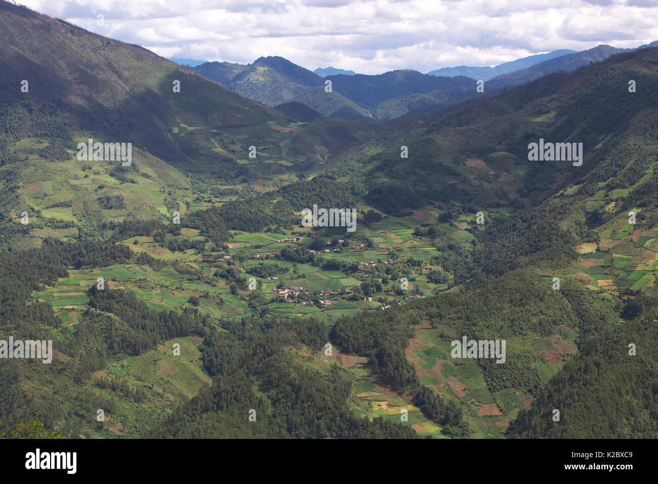 Paesaggio di montagna con città e campi terrazzati, Lijiang Laojunshan National Park, Yunnan, Cina, luglio 2007. Foto Stock