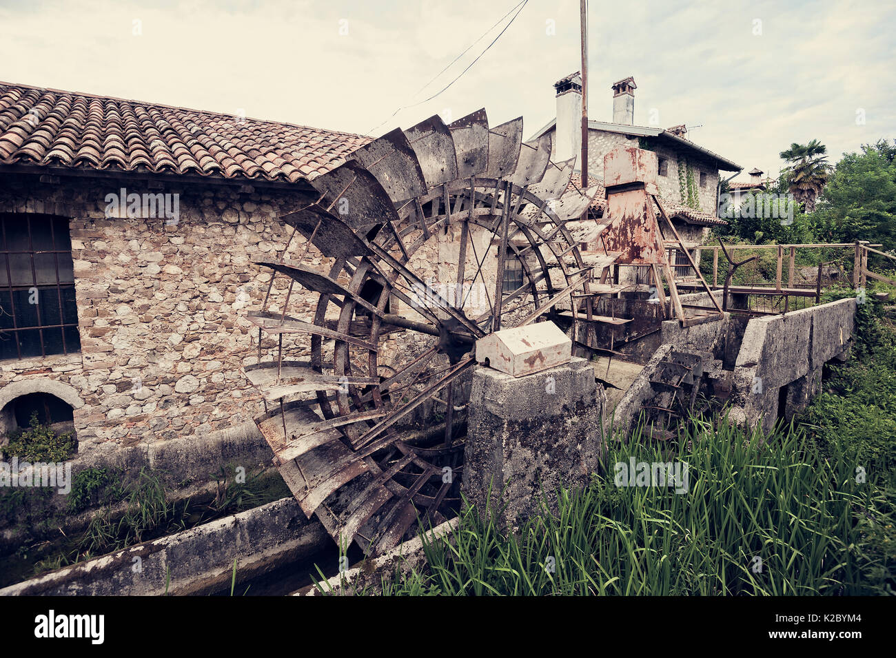 Antico mulino ad acqua con ferro ruota di acqua. Foto in stile vintage. Foto Stock