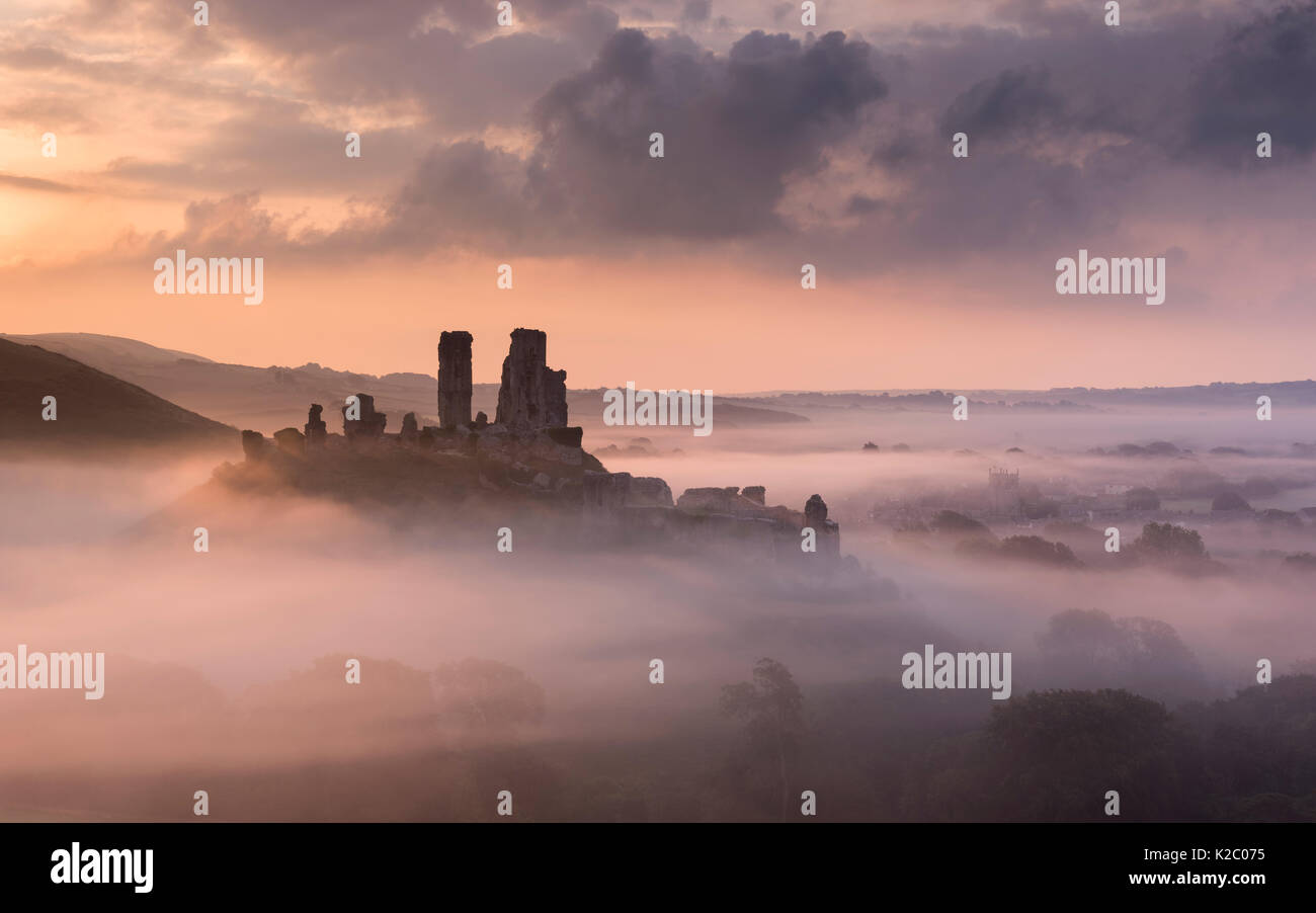 Corfe Castle e il villaggio nella nebbia mattutina, Corfe Castle, l'Purbecks, Dorset, Regno Unito. Settembre 2014. Foto Stock