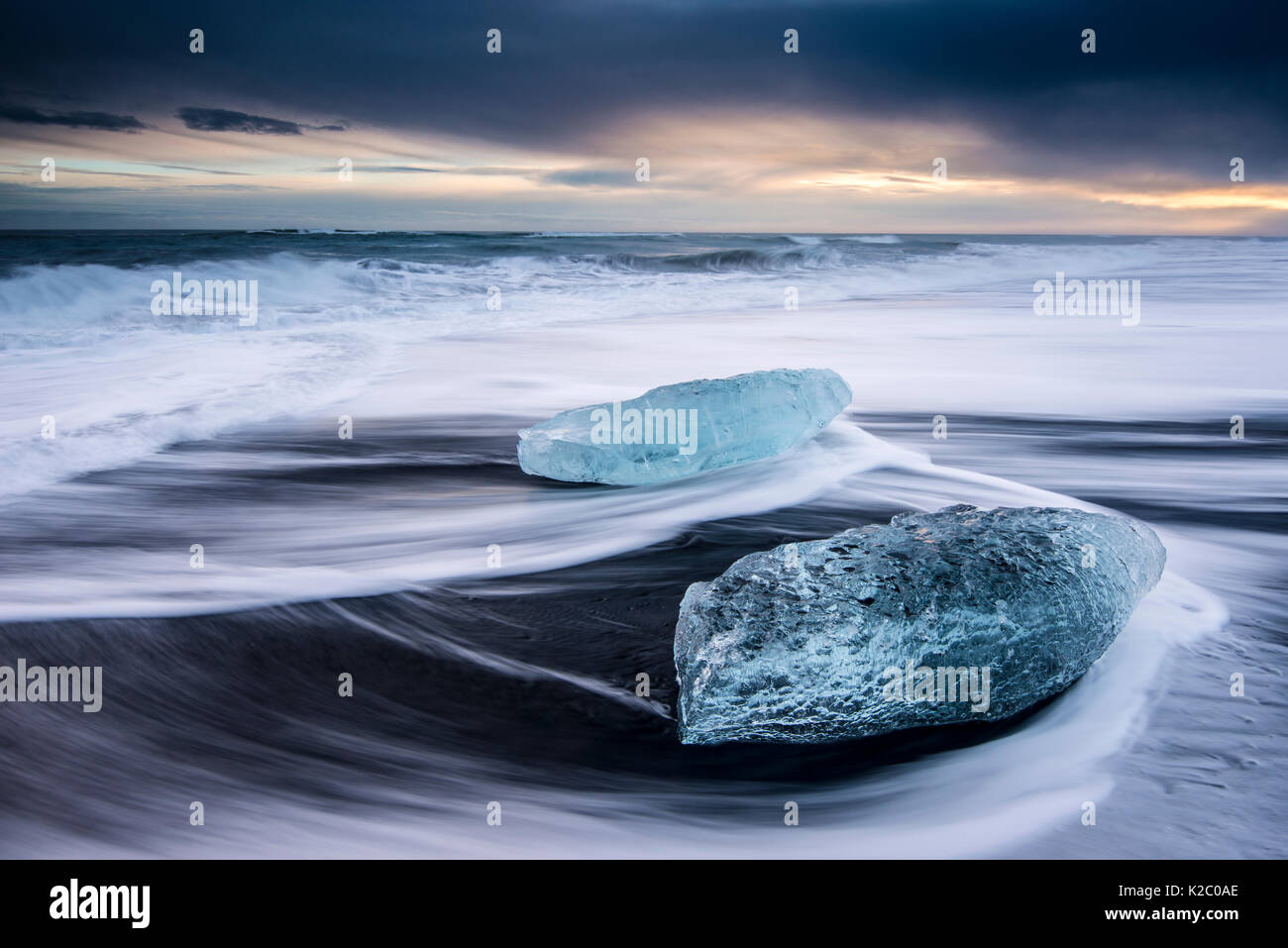 Ghiaccio sulla sabbia nera vulcanica spiaggia con onde, Jokulsarlon, sud-est di Islanda, febbraio. Foto Stock