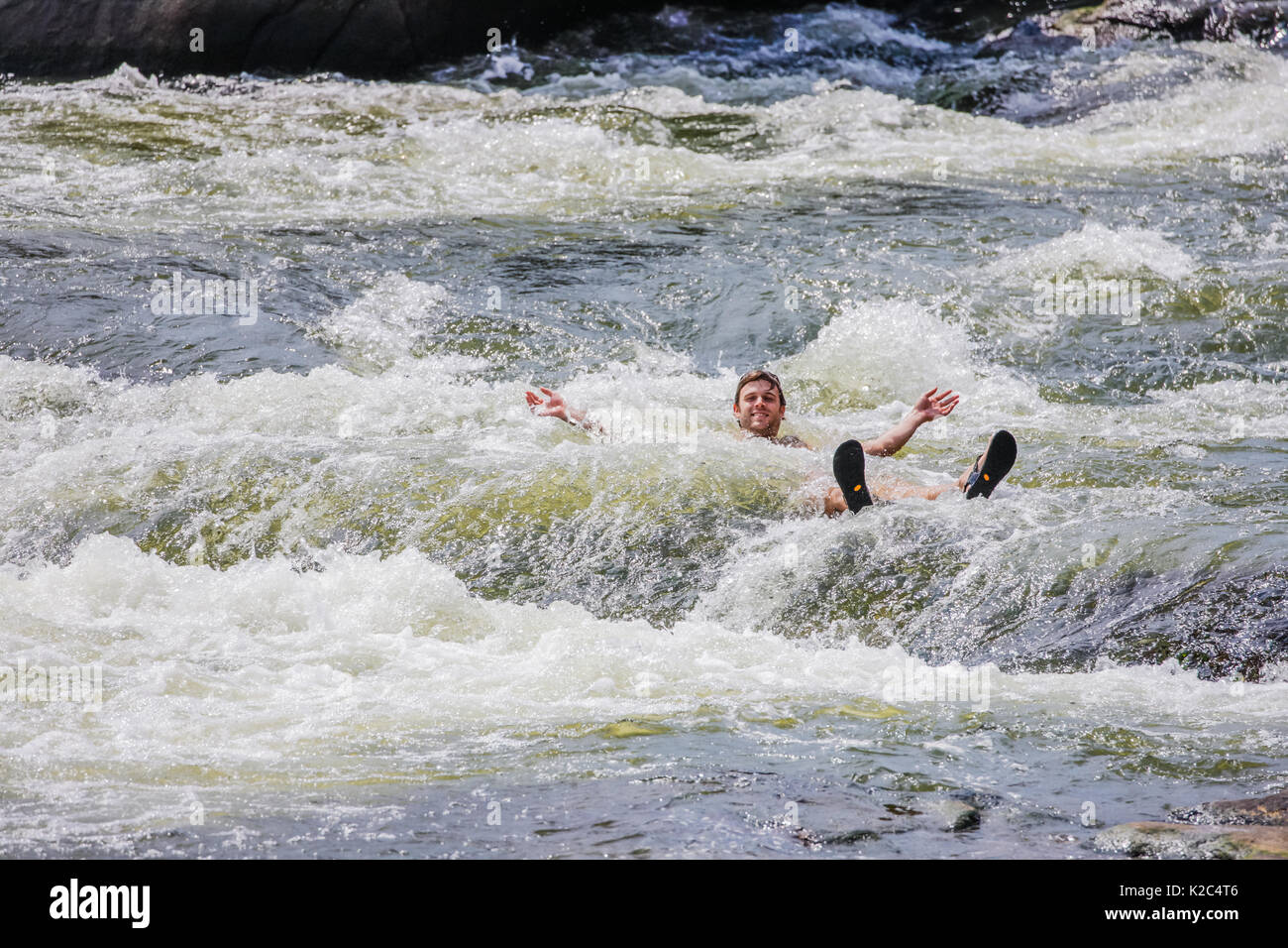 I giovani adulti il raffreddamento in James River rapids, Richmond, Virginia - Agosto 2017. Foto Stock