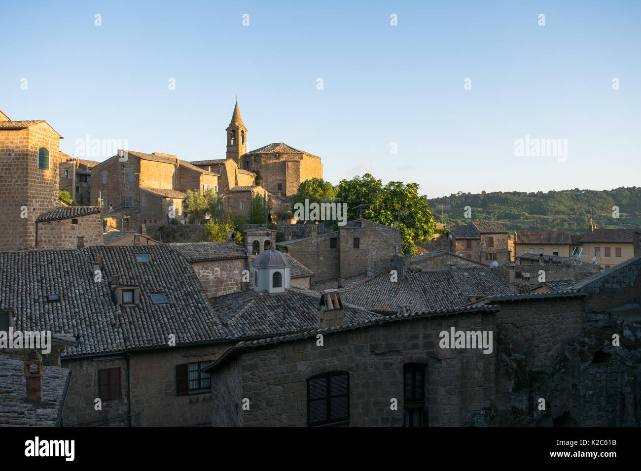 Gli edifici della casa e un prominente chiesa e torre campanaria a Orvieto Città Vecchia, Italia centrale, regione Umbria. La città mantiene un vecchio carattere medievale Foto Stock