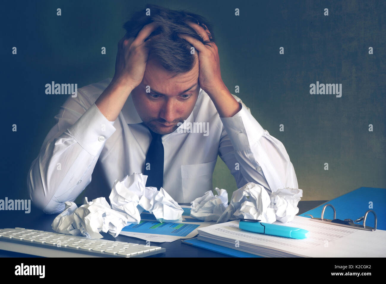 Spaventata business man cerca su sgualciti carta da ufficio. lo stress e la documentazione. Foto Stock