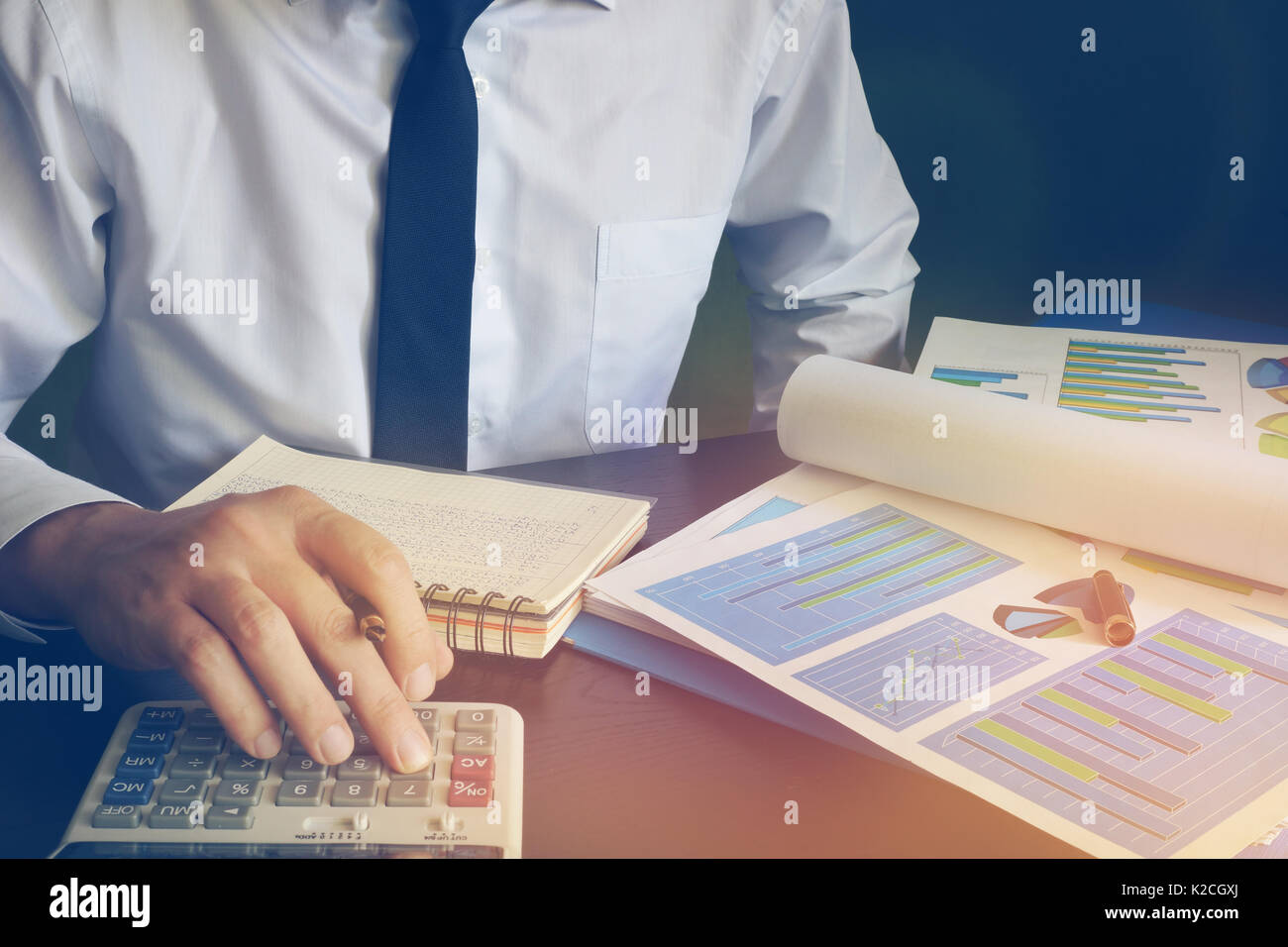 Business man utilizzando una calcolatrice per la creazione di report finanziari. Foto Stock